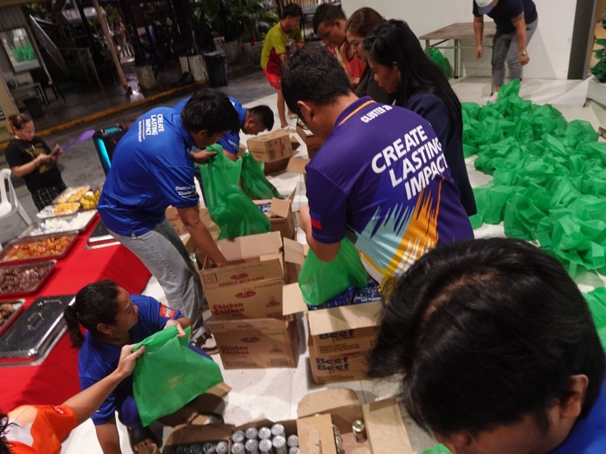 Members packing relief goods into green bags